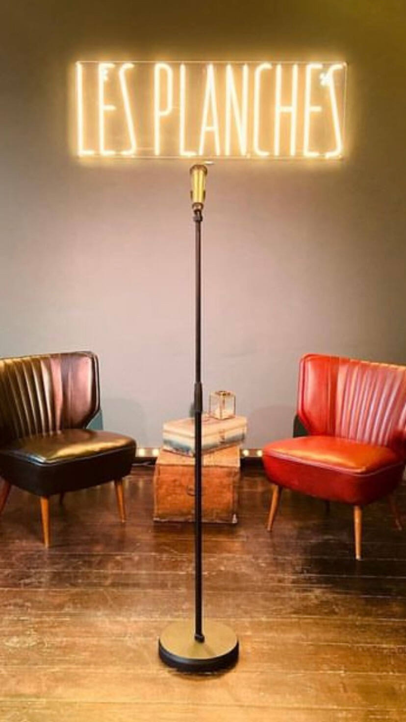 Un pied de micro vintage devant le néon, entre deux fauteuils