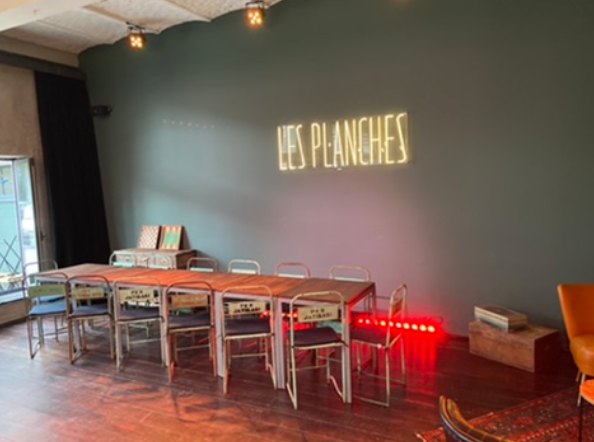 Les tables dressées devant le néon