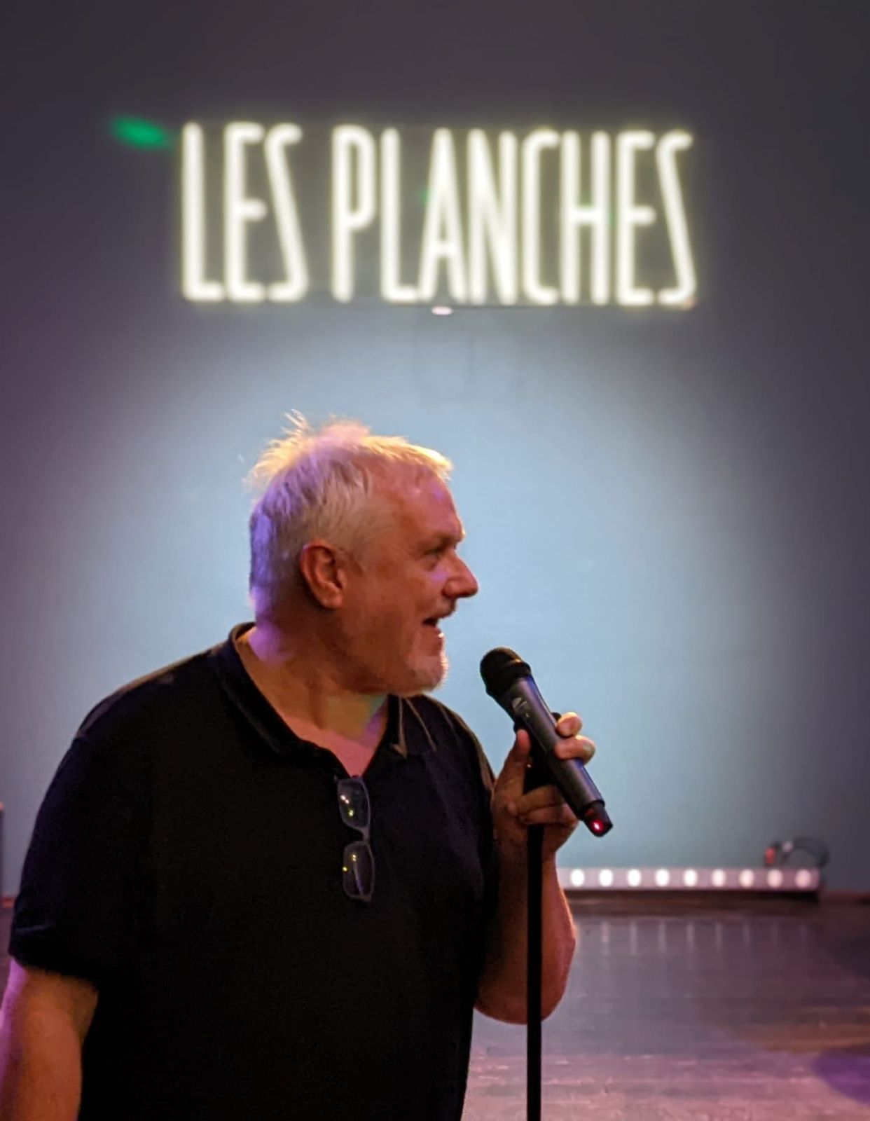 Prise de parole au micro devant le néon